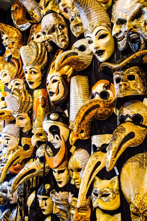 Free A vivid close-up of traditional Venetian carnival masks in various ornate designs and colors. Stock Photo
