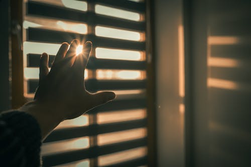 Hand Covering Sunlight From Window