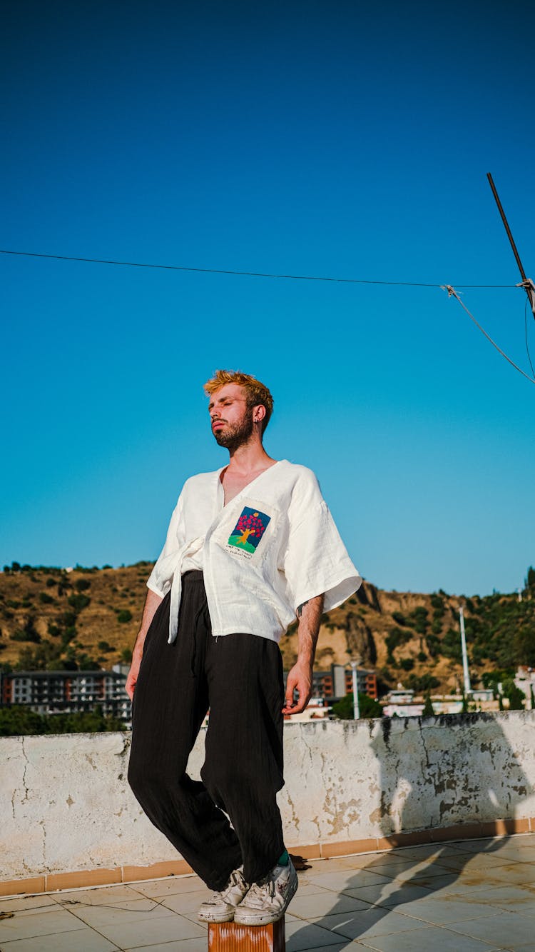 Young Man In White Shirt Balancing On A Brick