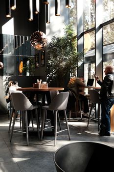 Sunlit modern café in Tbilisi with stylish furniture and relaxed atmosphere.