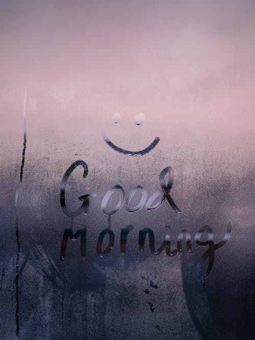 Free Smiley Face and Good Morning Text Painted on a Foggy Window  Stock Photo