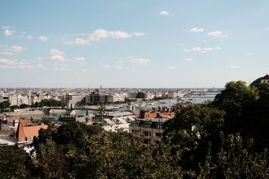 Scenic view of Budapest with the Danube River and historic buildings under a clear blue sky.