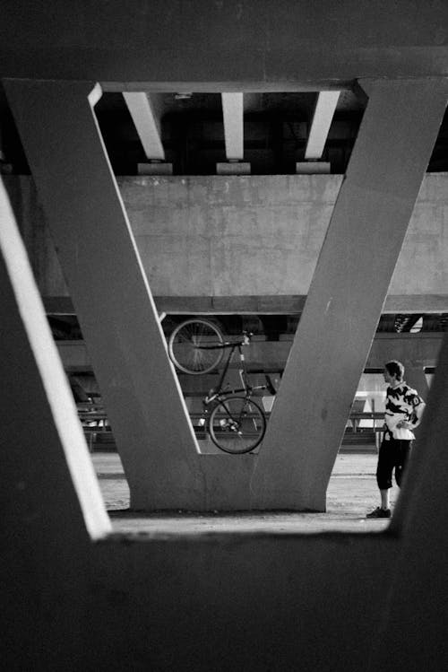 Black and White Shot of a Bicycle under a Bridge