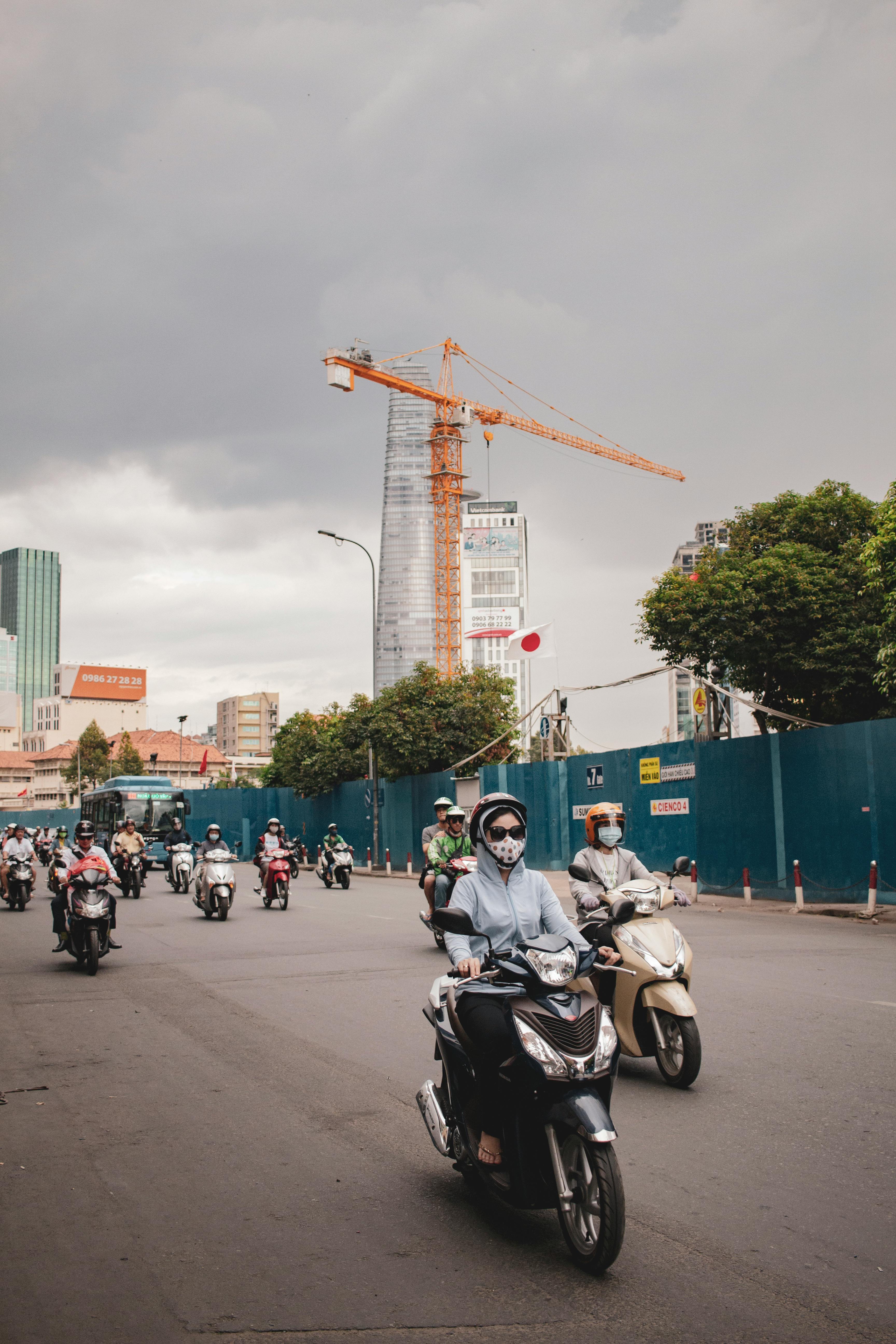 Free Motor scooters navigate the bustling city streets, showcasing urban daily life and traffic. Stock Photo