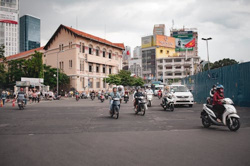 People on Motor Scooters on the Street in City 