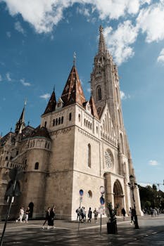 Stunning view of Matthias Church in Budapest, showcasing Gothic architecture against a clear blue sky.