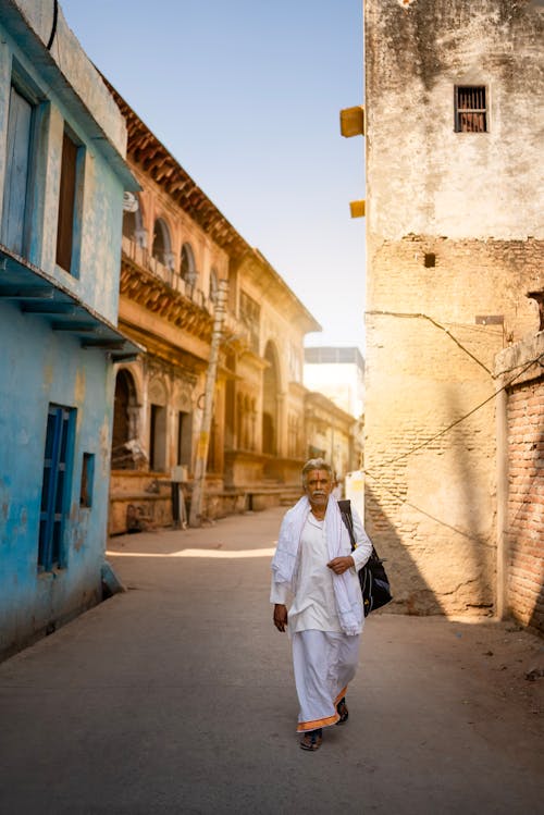 Elderly Man Walking down a Town Street 