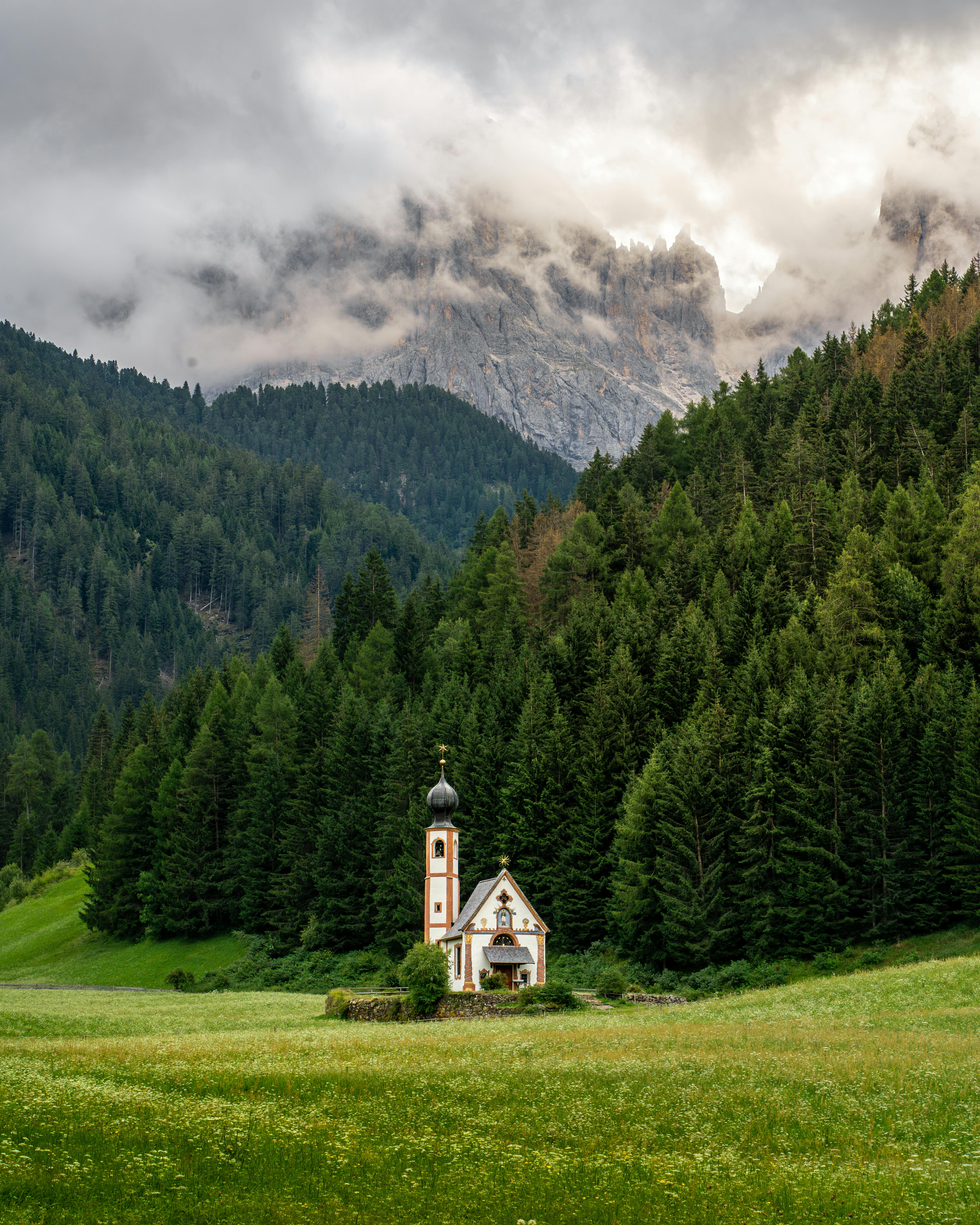 Picturesque church in lush Dolomite landscape, perfect for scenic wallpapers.
