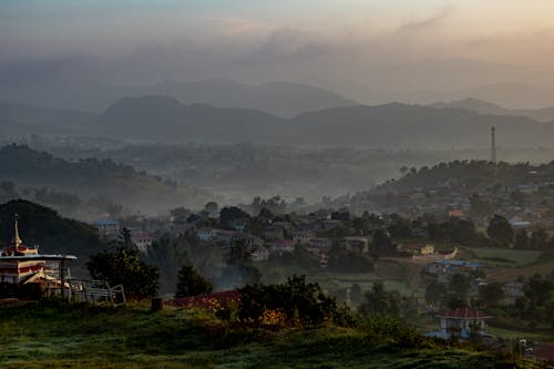 Town Surrounded by Mountains and Hills at Dusk 