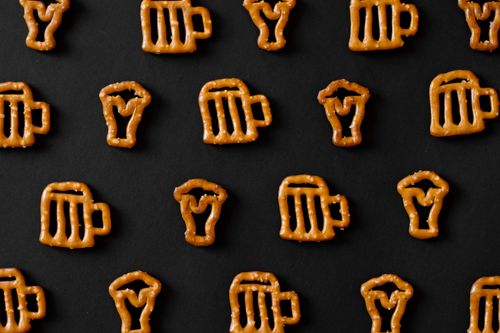 Free Top view of beer and cocktail glass shaped pretzels on a black background, perfect for snack and beverage themes. Stock Photo