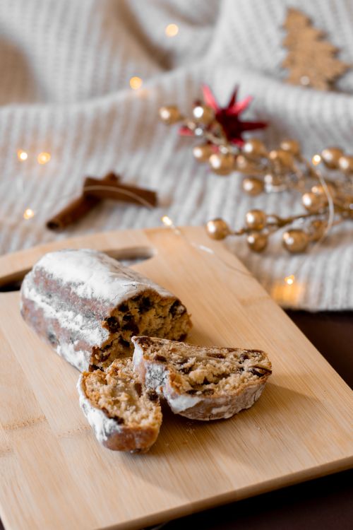 Free Delicious stollen cake surrounded by Christmas decor, perfect for festive celebrations. Stock Photo