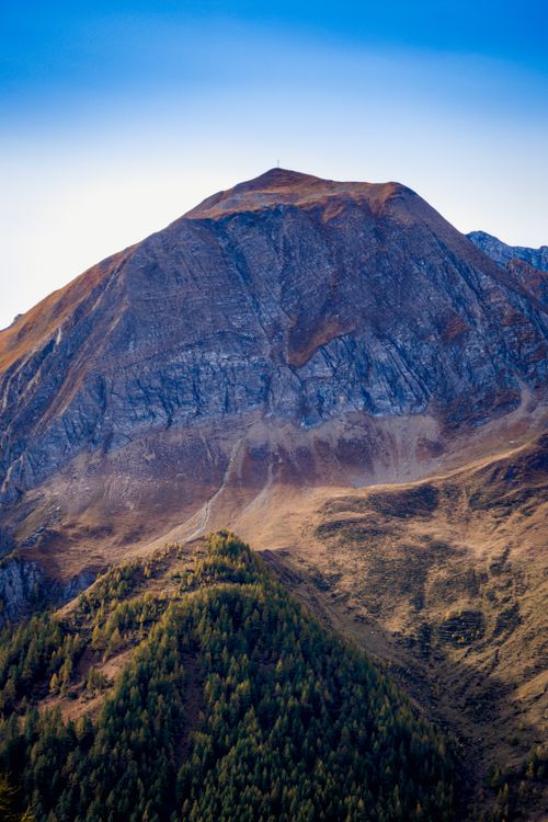 Free Breathtaking view of a rugged and eroded mountain under a clear blue sky, showcasing nature's majesty. Stock Photo