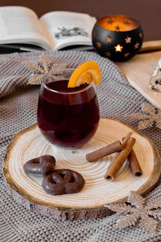 Warm drink with a slice of orange on a wooden tray, ideal for cozy winter settings.