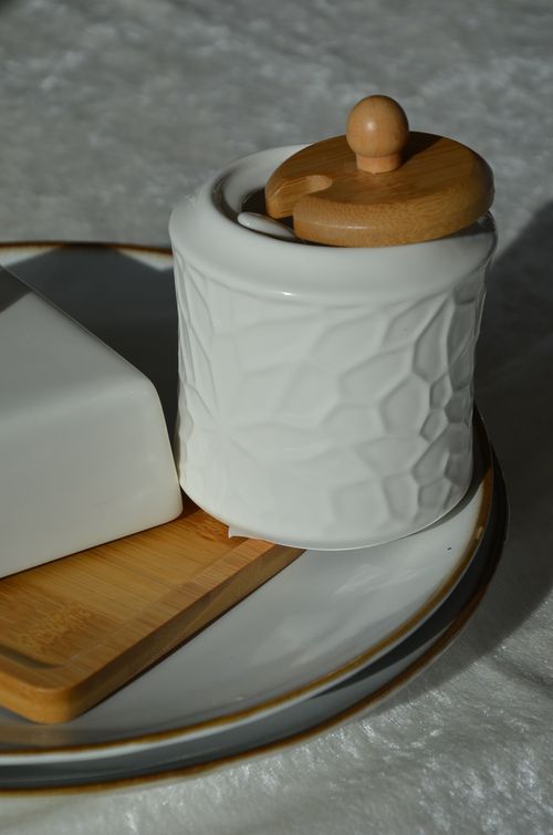 Free Stylish ceramic jar with wooden lid, perfect for home decor and kitchen storage. Stock Photo