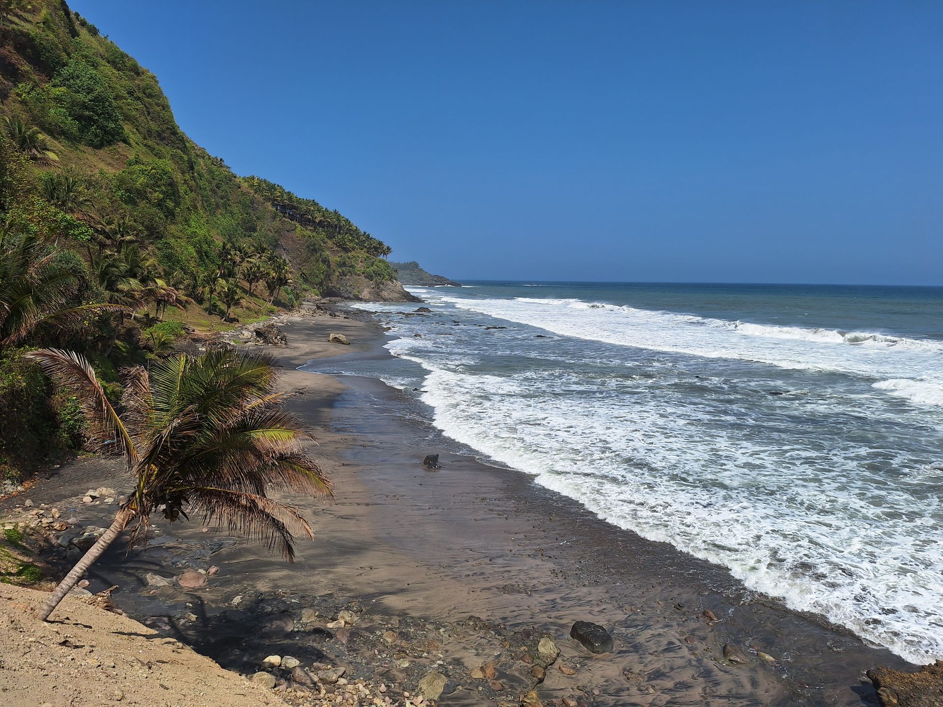 Discover the serene tropical beach of Kebumen, Java with lush cliffs and azure ocean waves.
