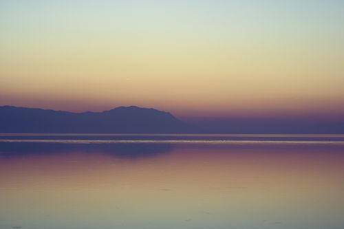 Free Peaceful sunset landscape with misty mountains and lake reflection. Stock Photo