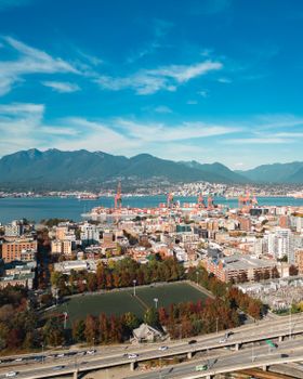 Stunning aerial view of Vancouver, BC showcasing the cityscape with mountains and harbor under a clear blue sky.