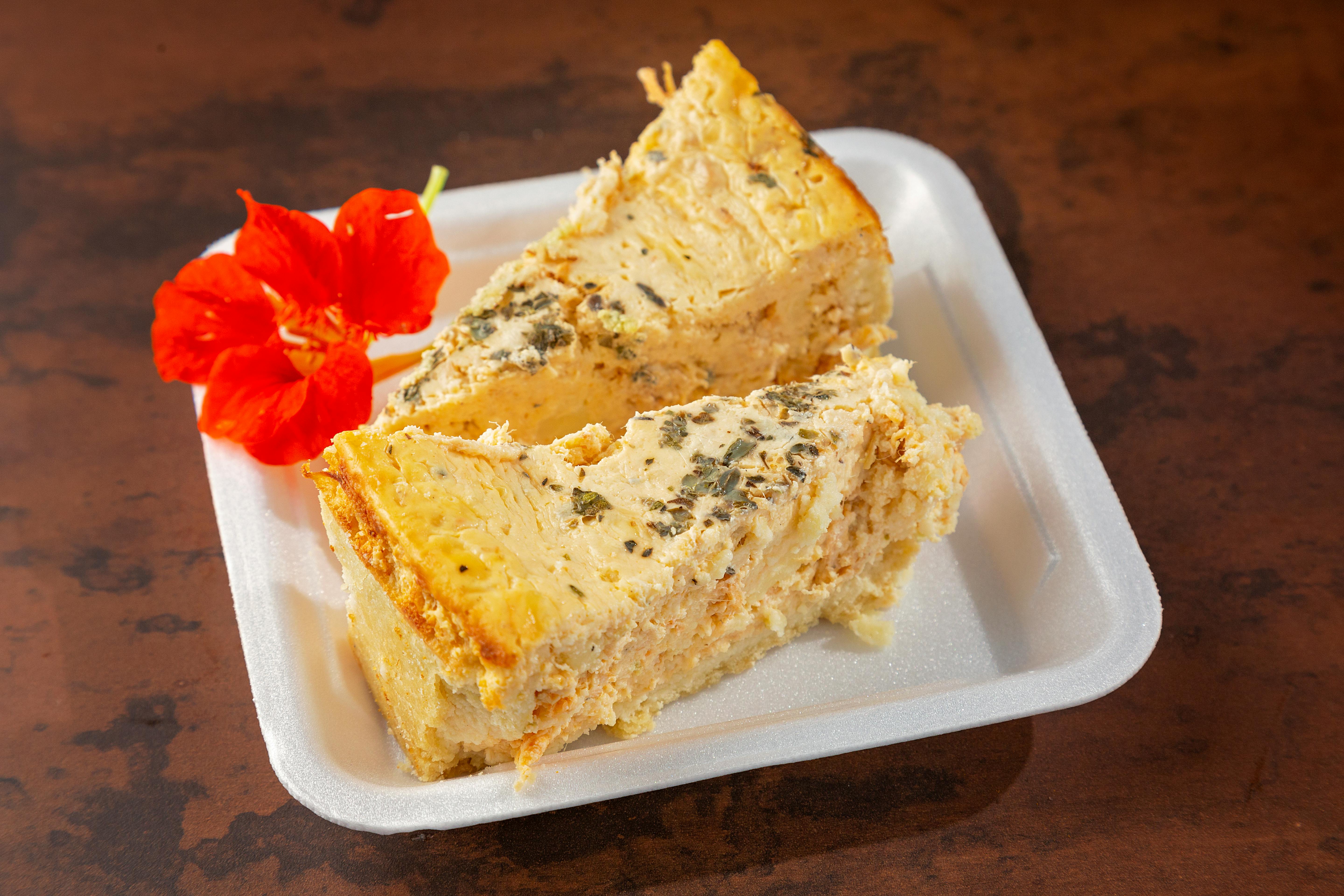 Close-up of two quiche slices with an edible flower on a plate, perfect for food photography.
