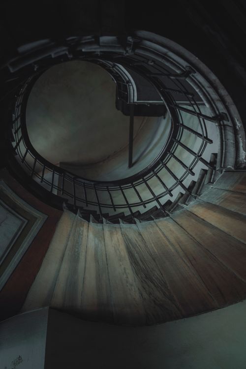 Free Moody vertical shot of a spiral staircase showcasing craftsmanship and design intrigue. Stock Photo