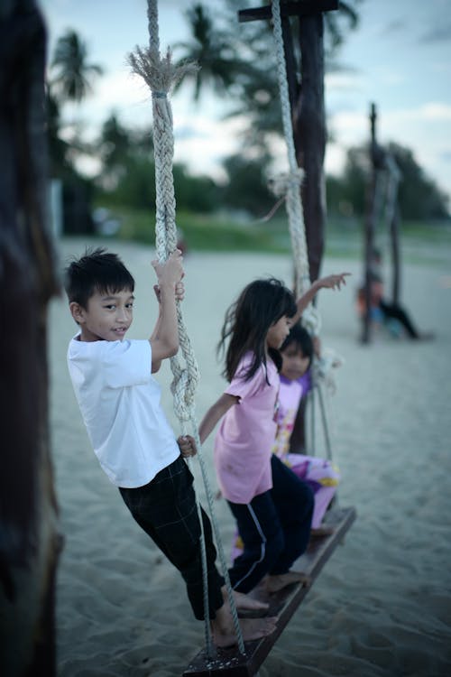 Kids Playing on Swing on Beach