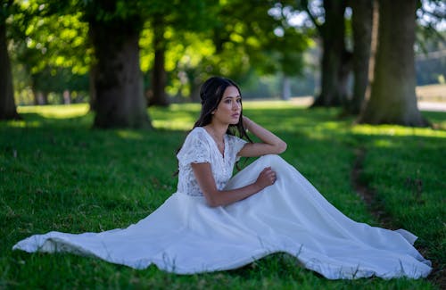 Bride Sitting on the Grass in a Park 