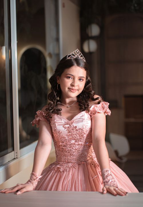 Free Beautiful young girl posing in a pink ball gown with tiara indoors, showcasing elegance and fashion. Stock Photo