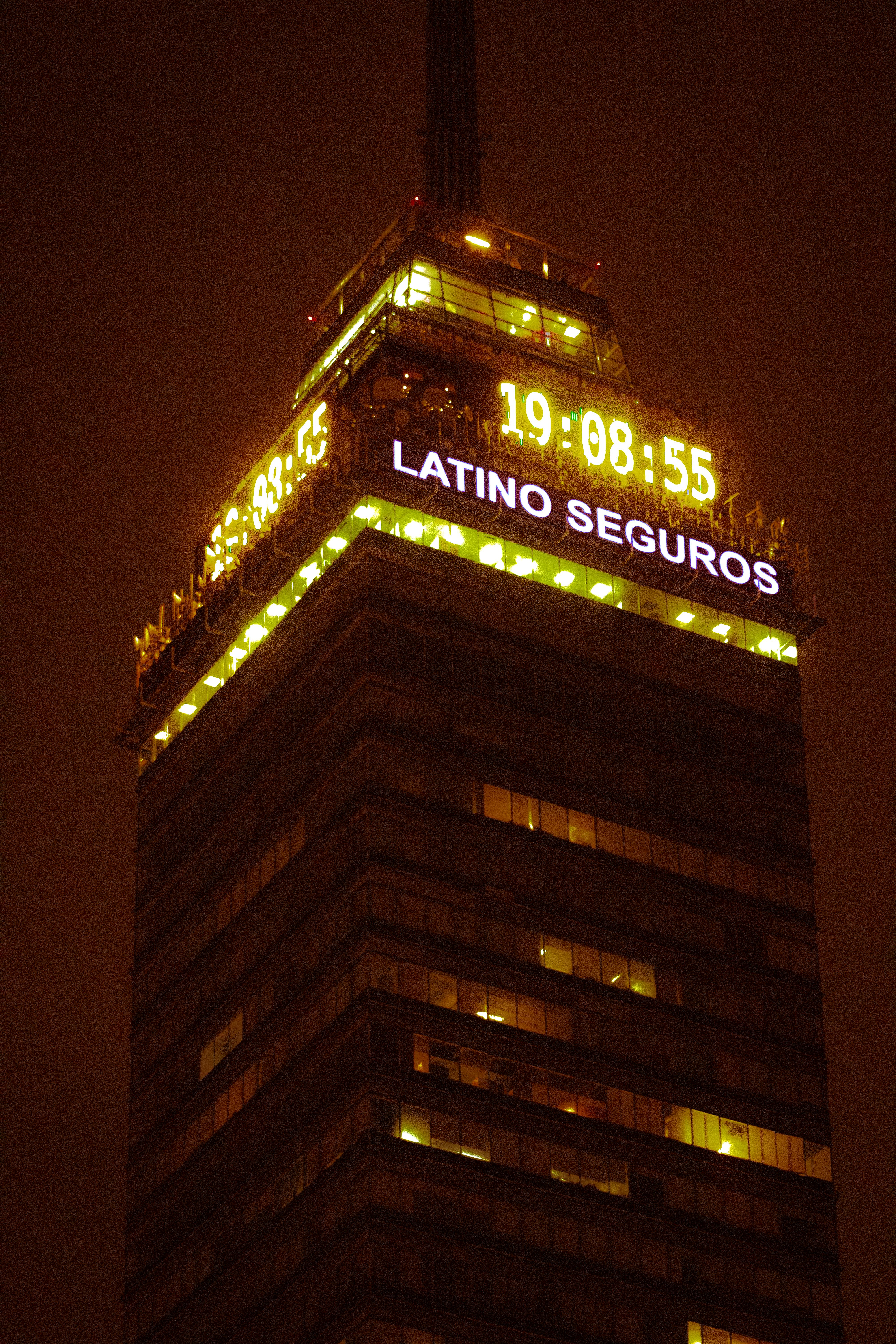 A dramatic night shot of Torre Latinoamericana, illuminated against the dark sky in Mexico City.