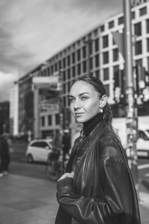 Pretty Young Woman in a Leather Jacket on the Sidewalk