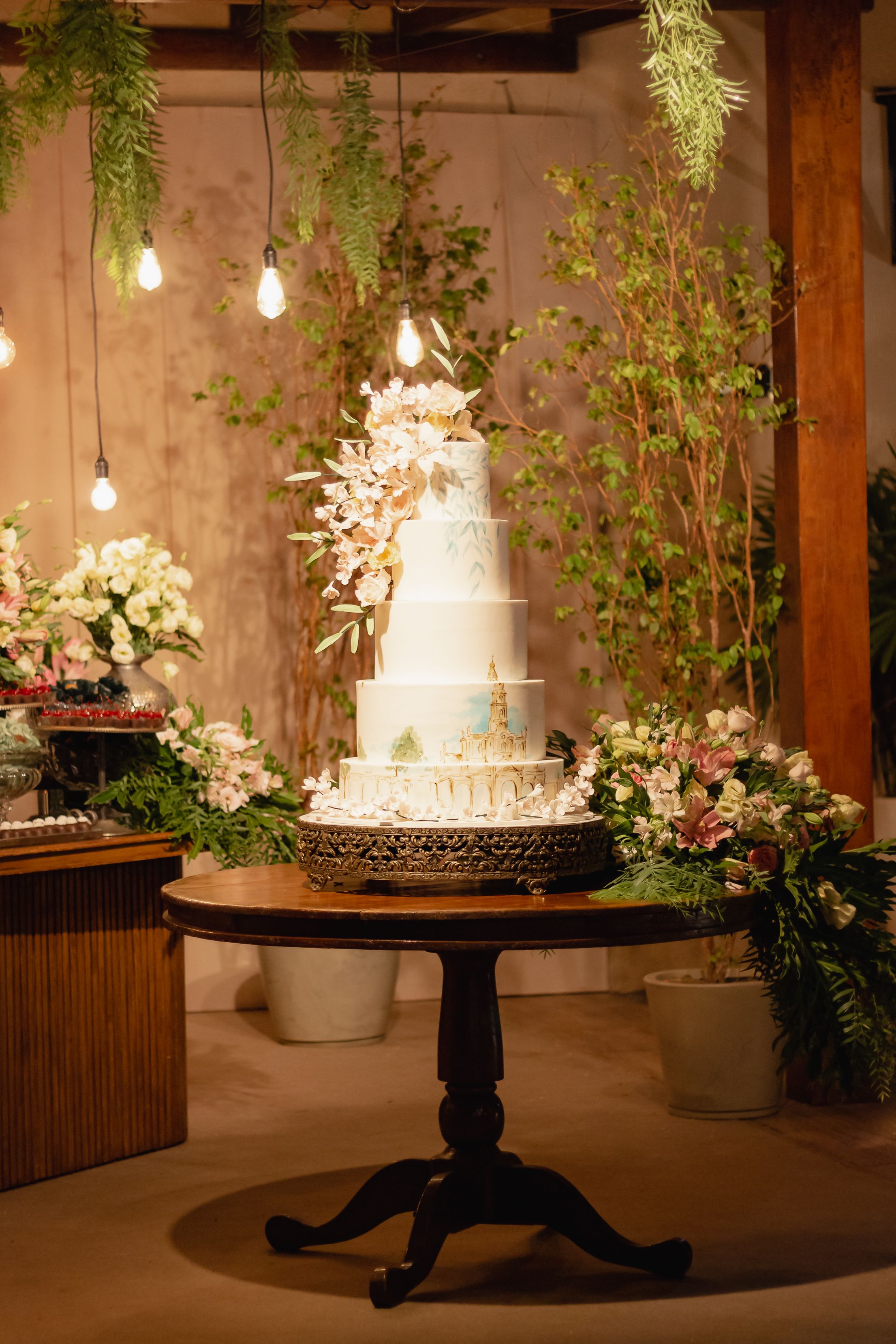 A tiered cake under festoon lights