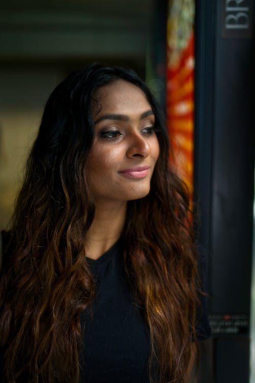 Young Woman with Long Brown Hair Looking Away and Smiling 