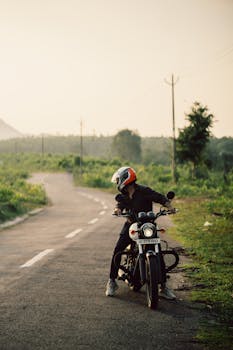 A biker in a helmet rides along a scenic road, capturing the essence of travel adventure.
