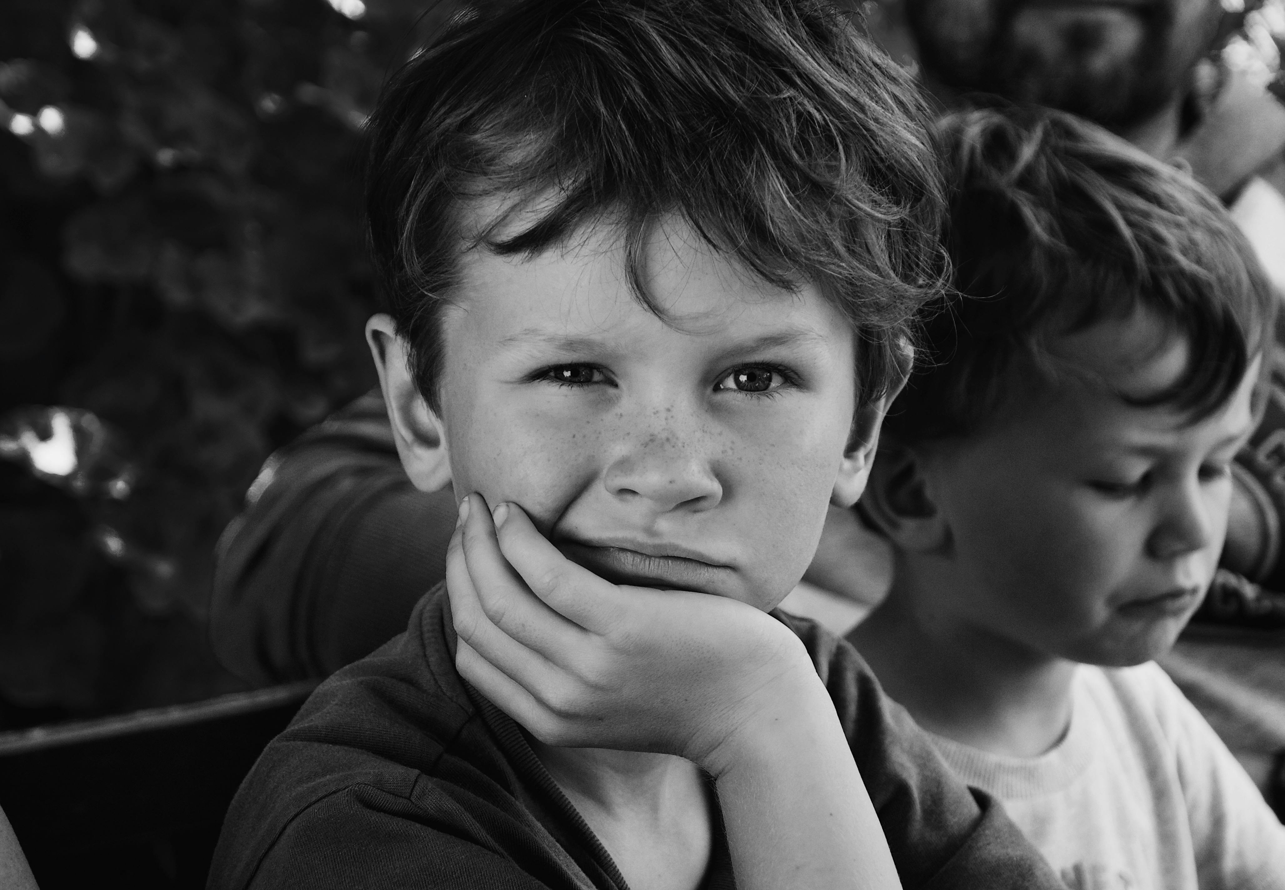 Expressive black and white portrait of two young brothers with thoughtful expressions.