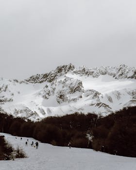 Panoramic view of snowy mountains and hikers in Ushuaia, Argentina.
