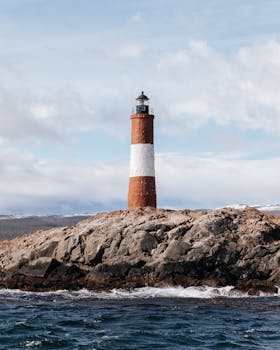 Majestic view of Les Eclaireurs Lighthouse on rocky shores in Ushuaia, Argentina.