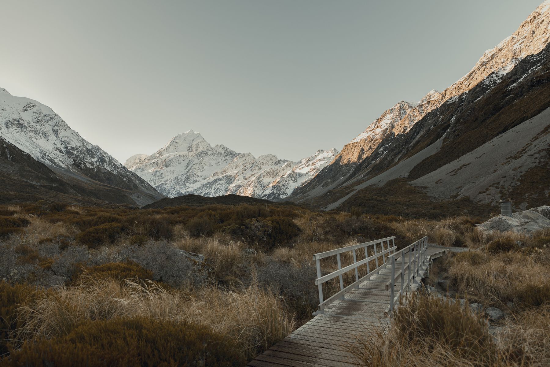 Footbridge and snowcapped peaks in Hooker Valley at Aoraki / Mount Cook National Park