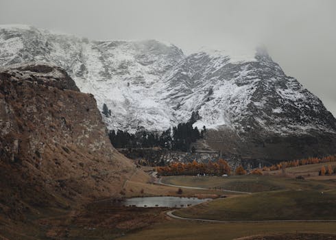 Breathtaking view of a snow-capped mountain near a tranquil lake in Queenstown, New Zealand.