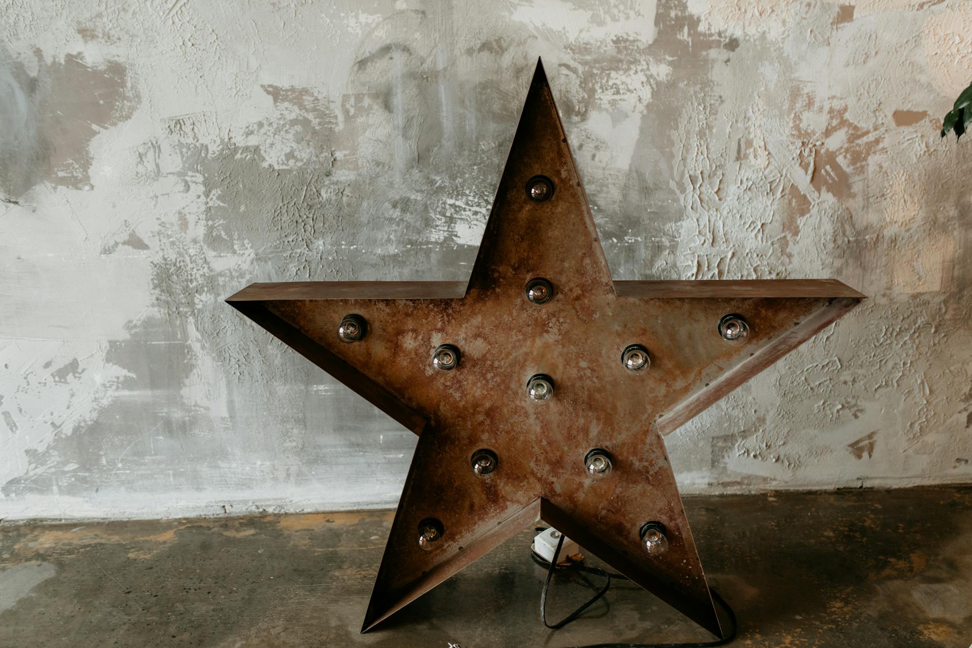 Vintage-style metal star with bulb lights, perfect for rustic interior decor.