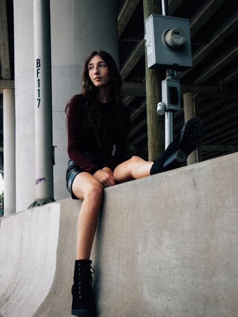 Woman in urban setting under a bridge in Atlanta, GA, showcasing modern street fashion.