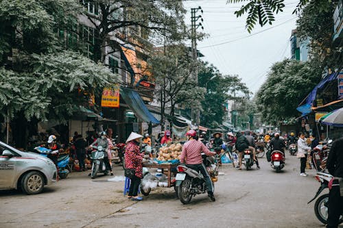 People on Motor Scooters on the Street Market 