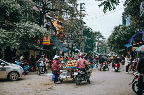 Free A bustling street market in Lạng Sơn, Vietnam with motor scooters and vendors creating vibrant urban life. Stock Photo