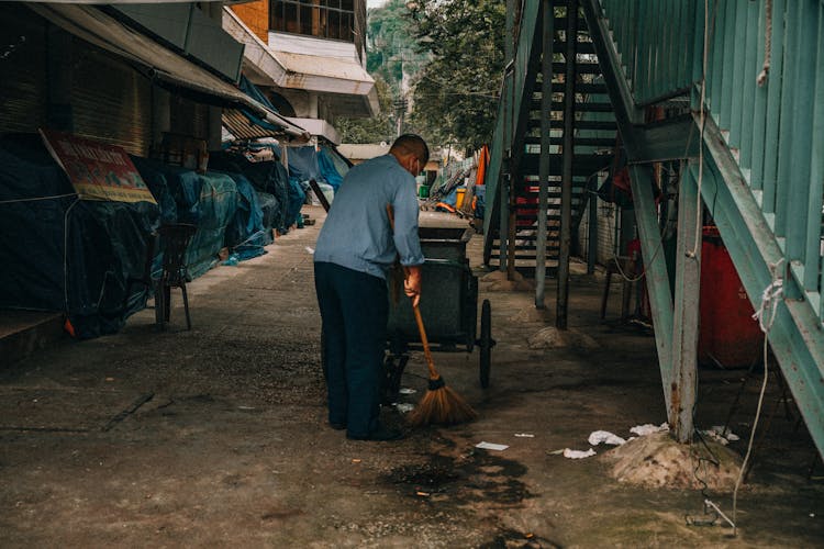 Man Cleaning The Street In City 