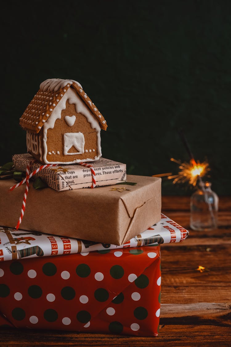 Gingerbread House On A Stack Of Wrapped Christmas Gifts