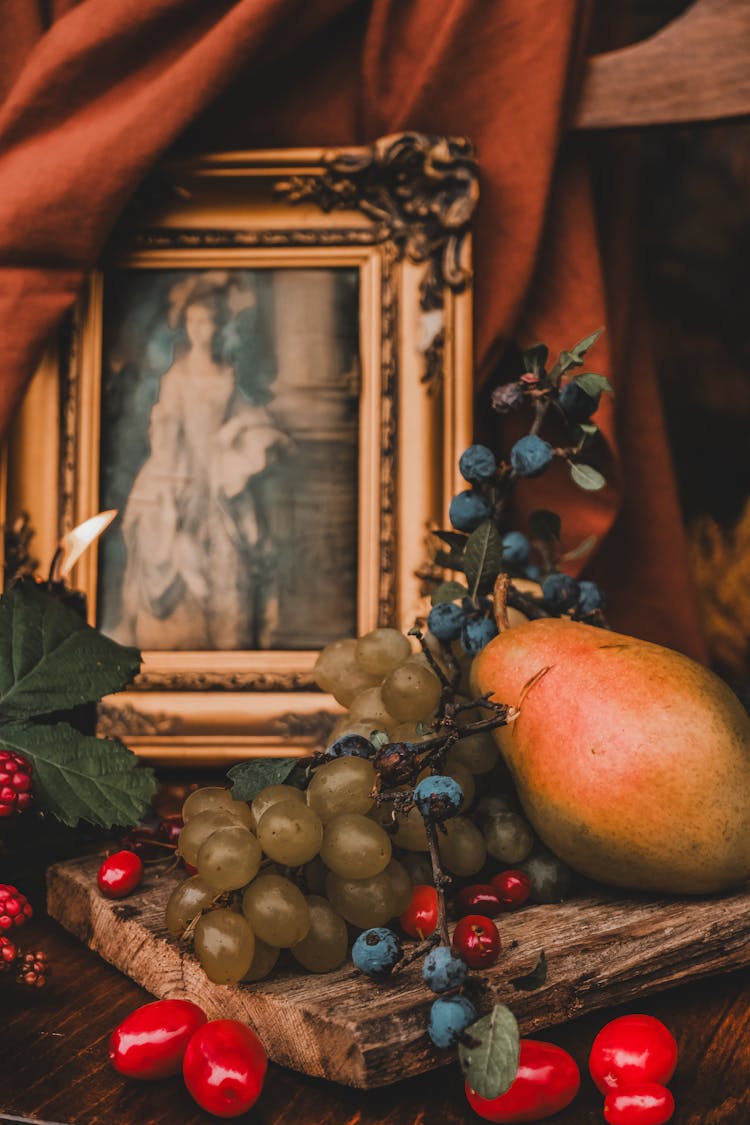 Fruits In Front Of An Old Fashioned Picture