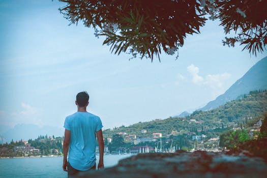 在意大利马尔塞辛的加尔达湖边，一名男子正欣赏着风景秀丽的景色和充满活力的夏季氛围