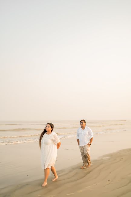 A serene scene of a couple walking on a beach at sunset, capturing a peaceful moment.
