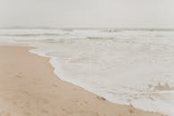 宁静的海滨，海浪轻柔，沙滩柔软，非常适合放松和寻找旅行灵感