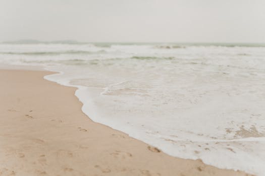 宁静的海滨，海浪轻柔，沙滩柔软，非常适合放松和寻找旅行灵感