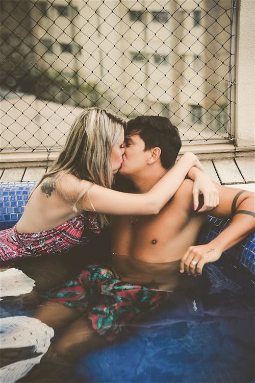 プールでキスしているカップルの写真