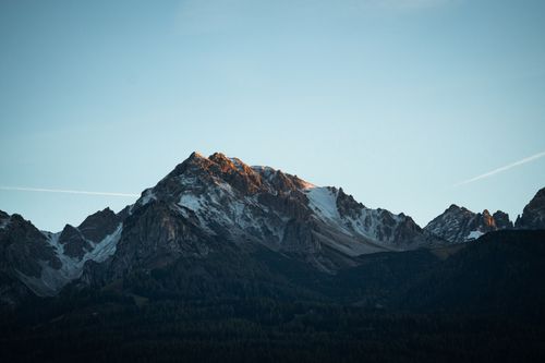 Free Dramatic view of snowcapped mountain peaks at sunset, with clear skies. Stock Photo