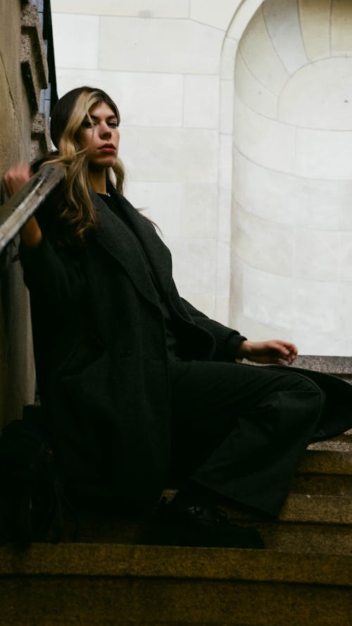 Model in a Gray Coat Sitting on the Stairs